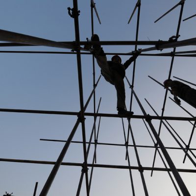 This photo taken on November 27, 2011 shows workers going about their chores on scaffolding at a construction site for a new shopping complex in Hefei, in eastern China's Anhui province. China will maintain restrictions on the property market, Vice Premier Li Keqiang has said, despite growing speculation that curbs could be eased to prevent a damaging slump in prices, as real estate sales and prices have been falling nationwide due to tough restrictions on purchases and bank lending, fuelling fears that the market could collapse and send debt-laden property developers to the wall.   CHINA OUT      AFP PHOTO (Photo credit should read STR/AFP/Getty Images)